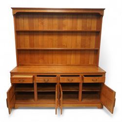 Seahorseman by Shaw & Riley - Yorkshire oak Welsh dresser, the dresser rack of rectilinear form with plain frieze and projecting moulded edge above two shelves with central shallow groove, the base section fitted with four drawers and a fitted cutlery drawer containing cutlery, above four panelled cupboard doors with geometric mouldings and carved sculpted handles, interior with single shelf and sides with geometric mouldings raised on a shallow plinth base with shaped bracket feet, with signature Seahorse carving from the workshop from the workshop of A. Shaw & Riley Ltd, Hessay