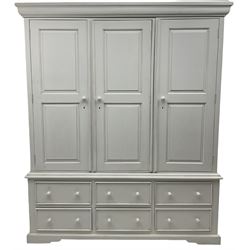White painted triple wardrobe, projecting moulded cornice over three panelled doors, the interior fitted with hanging rails, four drawers and hinged cupboard to base, on bracket feet