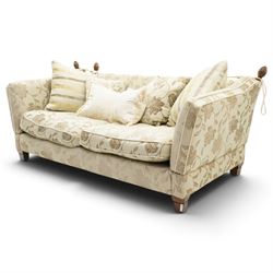 Traditional knoll sofa, upholstered in cream and olive floral fabric, adjustable drop ends secured by cords to turned finials, loose seat and back cushions with piped edges, on square tapering feet, with four scatter cushions