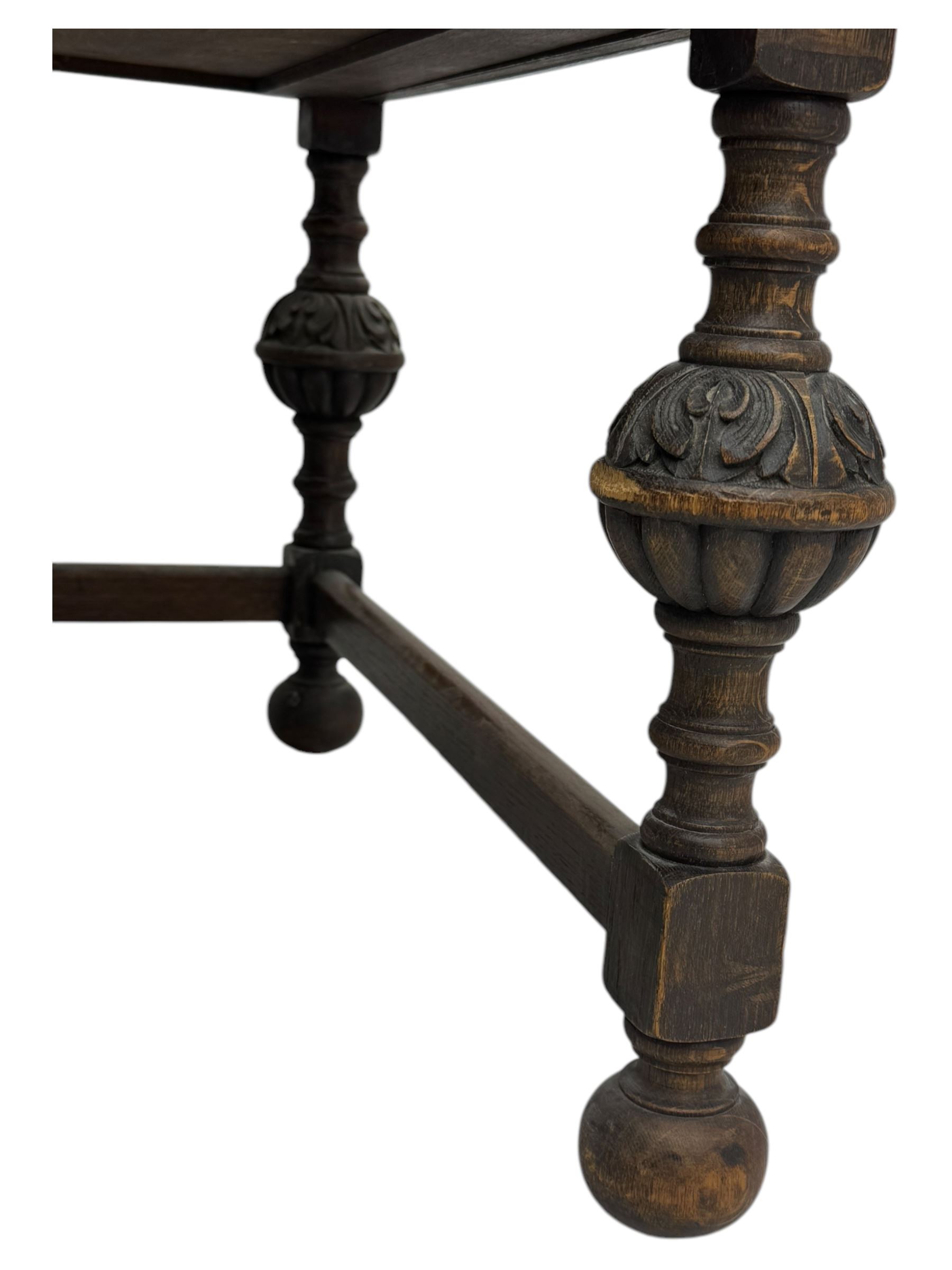 Early 20th century Jacobean design oak desk, with rectangular top inset with worn tooled leather, two frieze drawers over pedestals each fitted with a pair of panelled drawers, turned handles, on carved and fluted tapering legs united by stretchers 