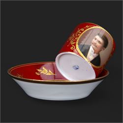 Late 19th century Vienna style coffee can and saucer, the cup with oval panel containing hand painted portrait of a gentleman, within a gilt foliate detailed surround, and upon a burgundy ground, the saucer with gilt band and sprigs upon a burgundy ground, with spurious shield mark beneath, cup H5cm saucer D12cm