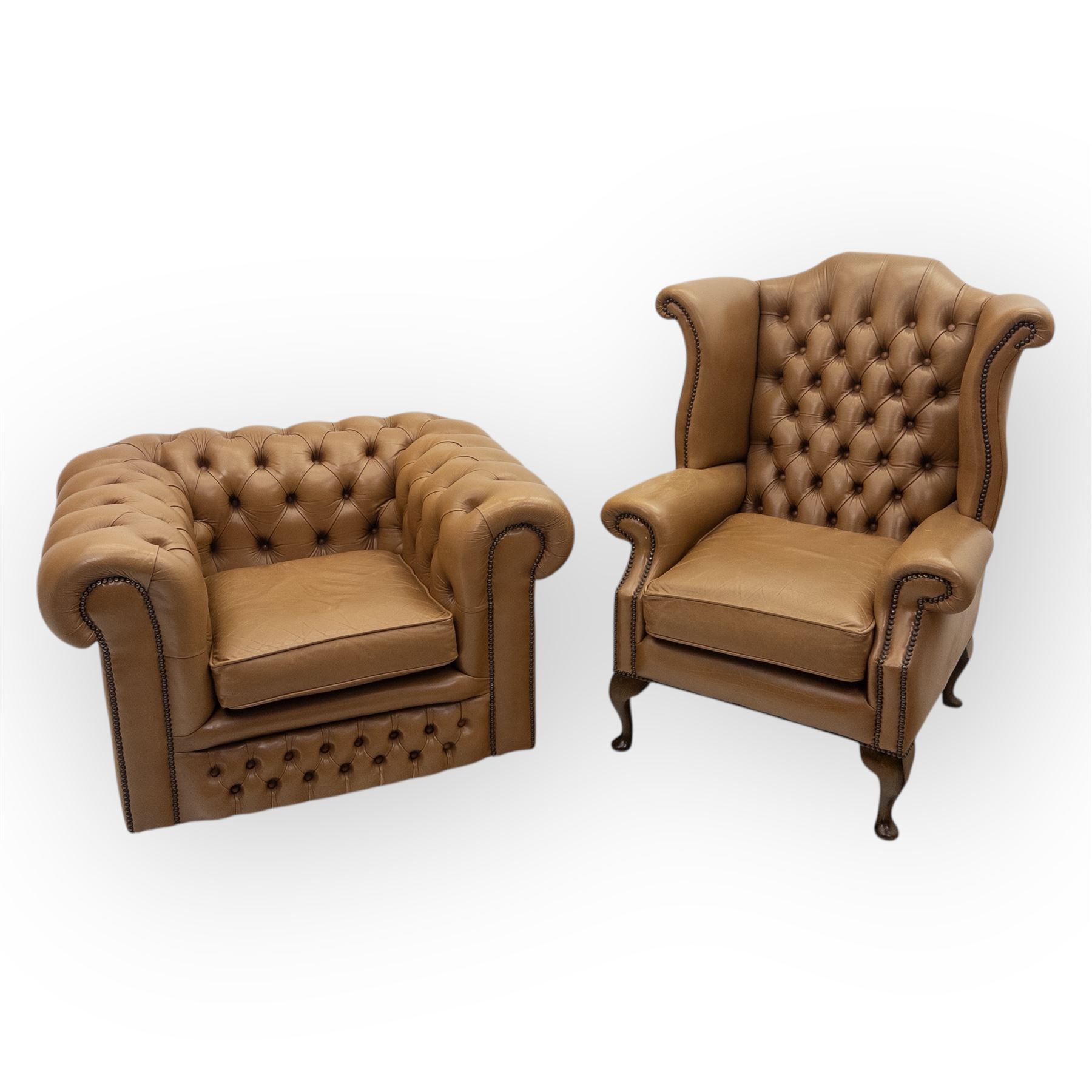 Contemporary set of two tan leather armchairs, comprising a deep-buttoned chesterfield and a matching wingback chair, both with rolled arms, studded borders