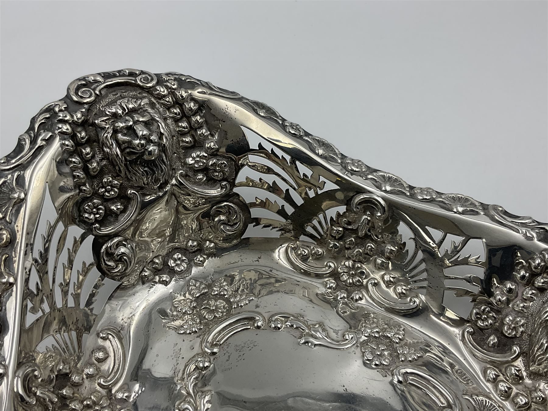 Edwardian silver swing handled basket, of navette form, with four repousse lion masks to each corner and with pierced and embossed floral, scroll and shell decoration to sides, base and handle, hallmarked Charles Horner, Birmingham 1906, height including handle H20cm