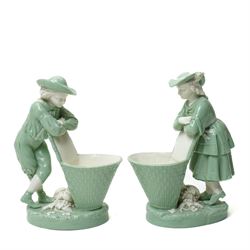  Pair of late 19th century Minton figures 'Grape Pickers' in pale green, each standing by ...