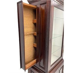 Mahogany display cabinet with hidden compartment, projecting cornice over single glazed door enclosing glass shelves, double panelled cupboard below, the interior with button releasing sliding back compartment, on bracket feet