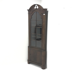  20th century walnut corner cabinet, arched swan neck pediment with central finial, single glazed door, two shelves, cupboard door, shaped bracket supports, W69cm, H191cm, D38cm  