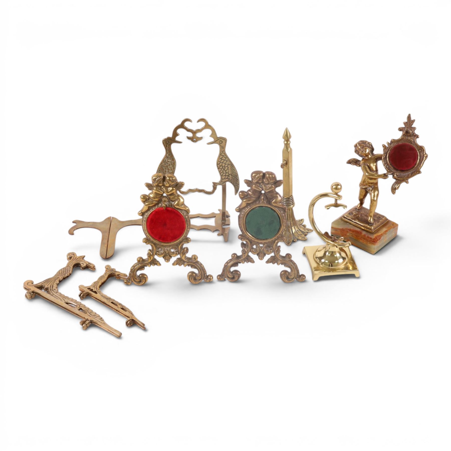 Collection of brass watch stands, including an example modelled as a cherub upon an onyx base, tallest H17cm  
