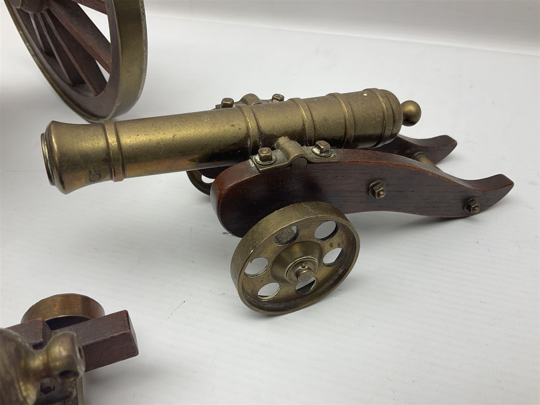 Large model brass cannon, upon wooden base, together with two similar smaller cannons, largest L48cm