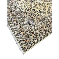 Persian Kashan ivory ground carpet, decorated all-over with interlacing foliate and stylised plant motifs, central scrolling medallion and matching spandrels, the guarded border decorated with repeating palmettes