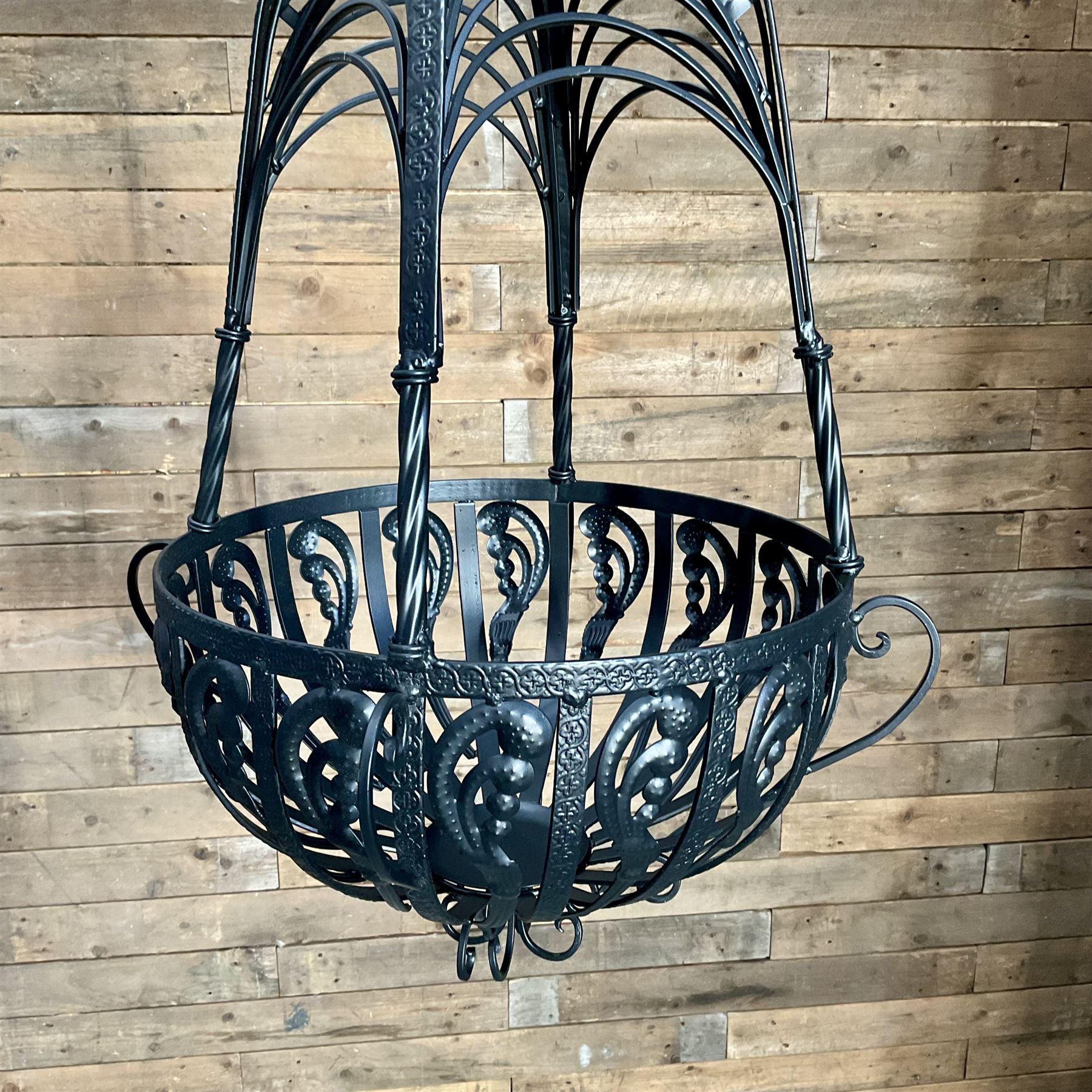 Pair of black finish wrought metal hanging baskets, with brackets