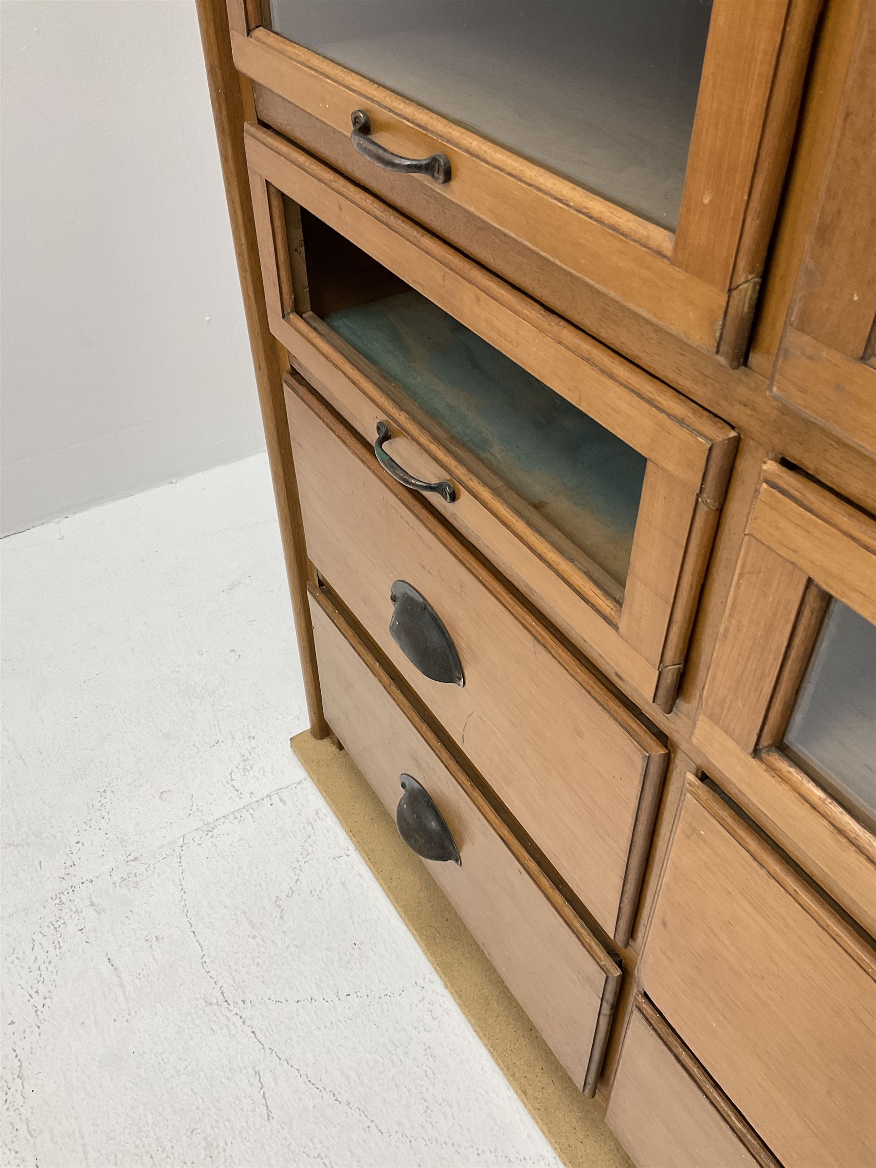 Haberdashery display cabinet with plaque ‘J.C. King Ltd, Shop fittings & Sundries, St John's Street London’, sixteen glazed front short drawers, above four deep drawers