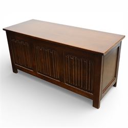 Late 20th century oak linenfold blanket box, with hinged rectangular top opening to a plain interior, the front carved with three linenfold panels, plain panelled sides, raised on stile supports