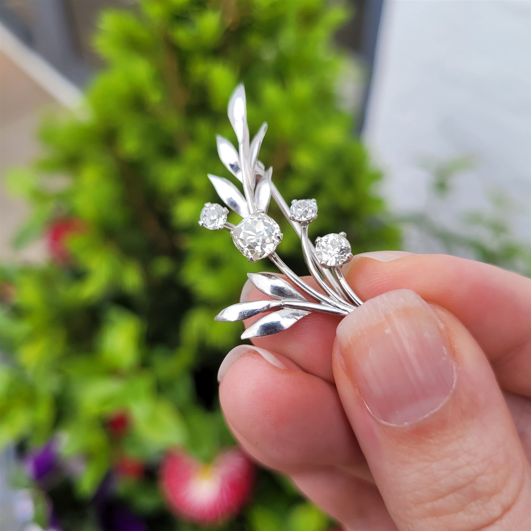 18ct white gold diamond flower brooch, set with a principal old cut diamond of approx 1.00 carat, surrounded by three further old cut diamonds, total diamond weight approx 1.75 carat