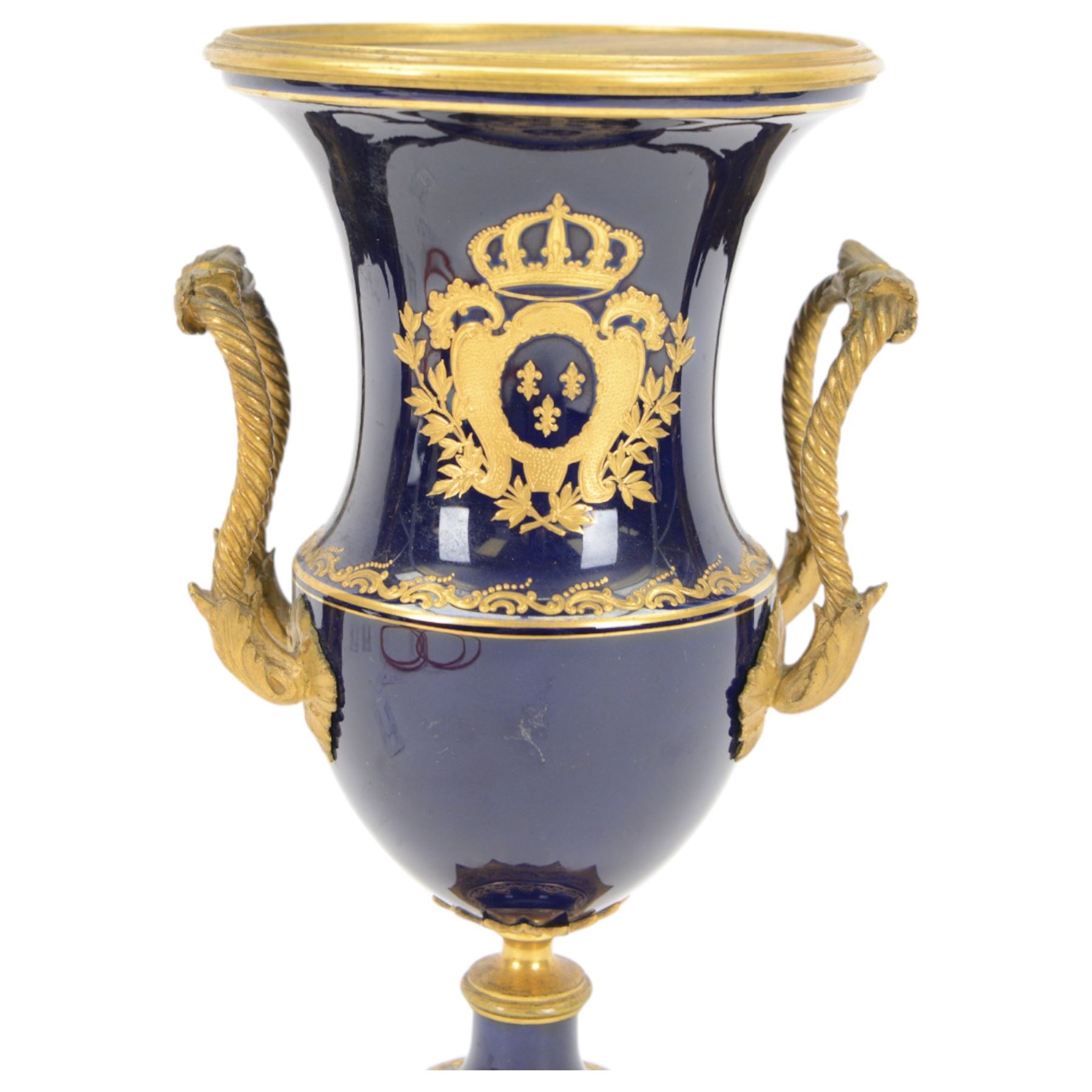 19th century Sevres style ormolu mounted porcelain twin handled urn, the body decorated with a gilt crowned crest of three fleur de lis against a cobalt ground, with spurious Sevres mark beneath, H26cm
