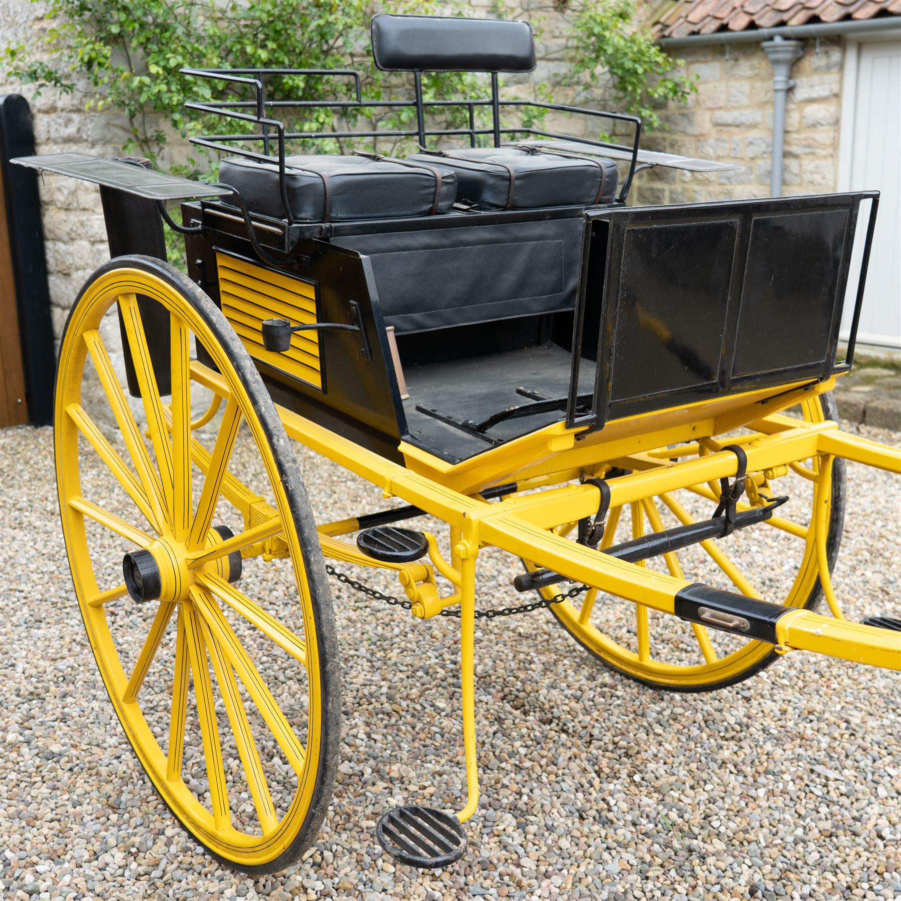 J. W. Thompson Dog Cart

A black and yellow painted two wheeled dog cart with elevated upholstered seat for two, buttoned black leather cushions, high back rail, folding front footboard, louvred sides, side steps, rear drop-down tailboard with chain stays, internal storage compartment, wooden spoked wheels, rubber tyres and shafts for a single horse. The wheel hubs are marked J W Thompson

Dimensions:
Overall length: 366 cm
Width: 160 cm
Height: 190 cm

Wheel Diameter:
Wheels: 139 cm

Seating:
Driver and passenger: 2