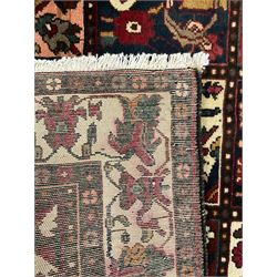 Persian Bakhtiari burgundy and ivory ground rug, with square floral motifs, repeating border