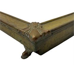 19th century brass fender, the front corners set with cartouche mounts, scroll moulded feet
