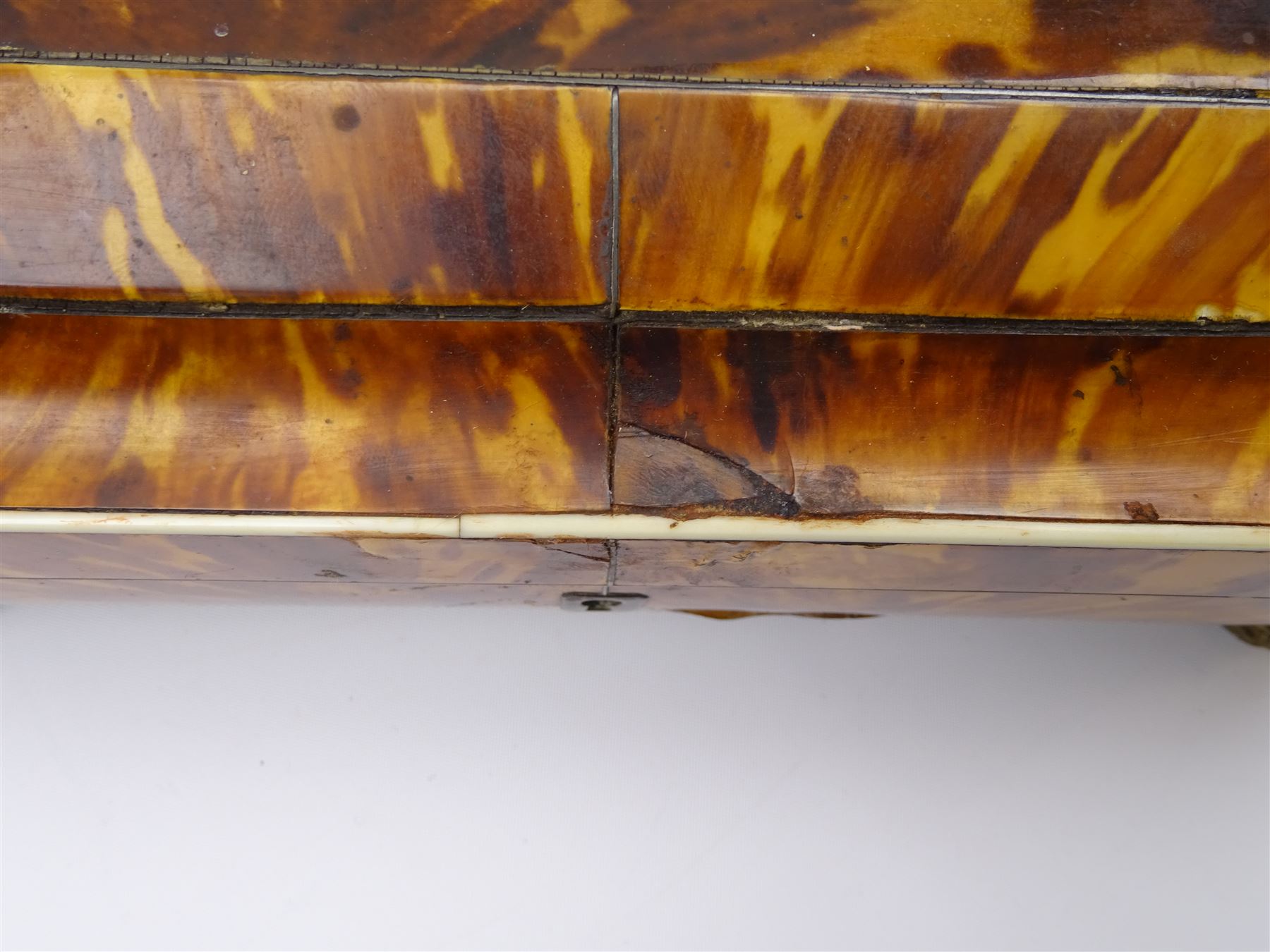 19th century tortoiseshell sewing box, of sarcophagal form upon four foliate detailed brass ball feet, the hinged cover edged in ivory with initialled silver plaque to centre, opening to reveal a silk lined interior, H9.5cm W22.5cm D18cm