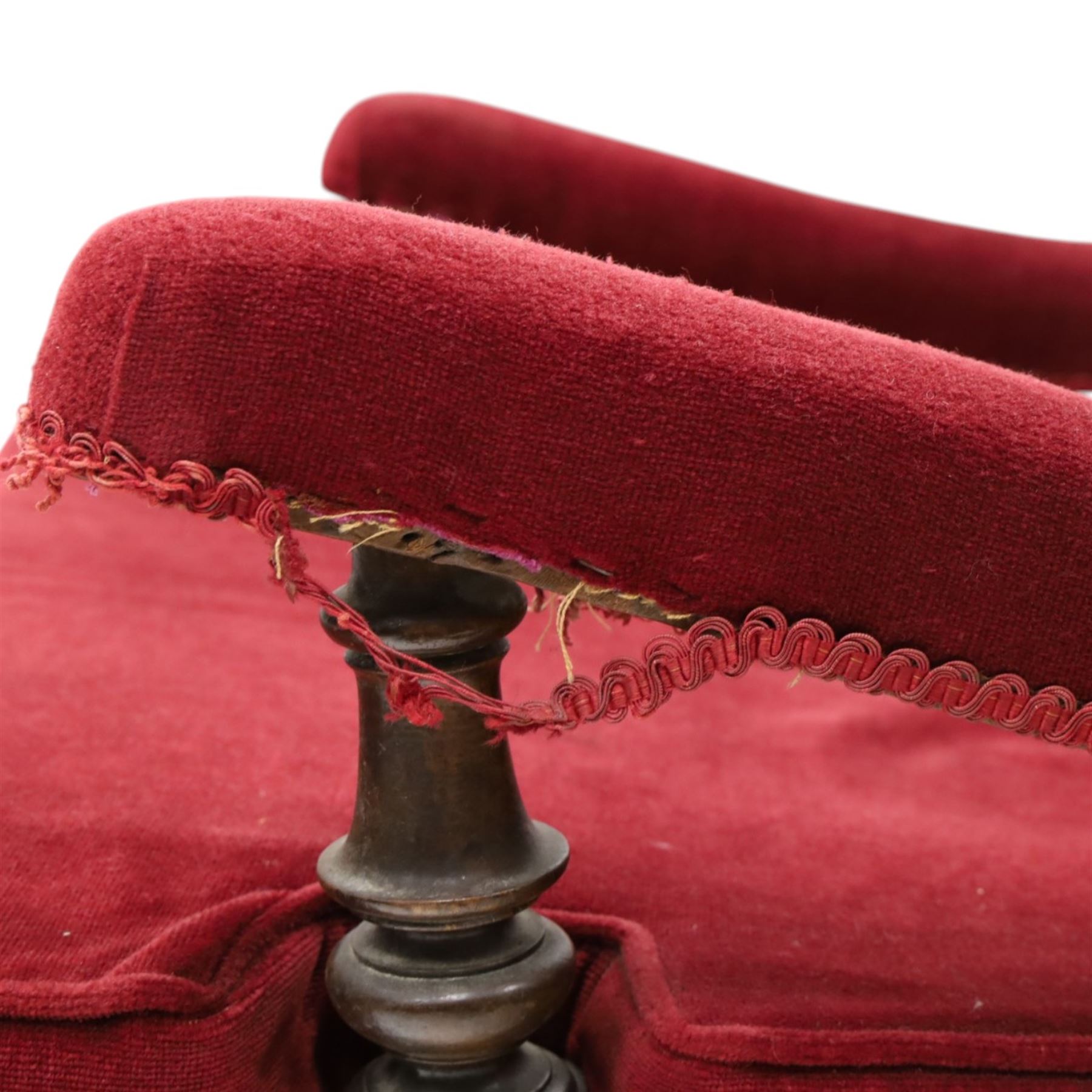 Victorian walnut framed reading open armchair of reclined position, the high sprung back and deep seat upholstered in crimson fabric with matching loose seat cushion, turned arm terminals over turned feet terminating to brass castors
