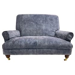 Traditional shape hardwood framed two-seat sofa, high back over deep seat and rolled arms, on turned front feet with brass cups and castors, upholstered by Plumbs in blue fabric