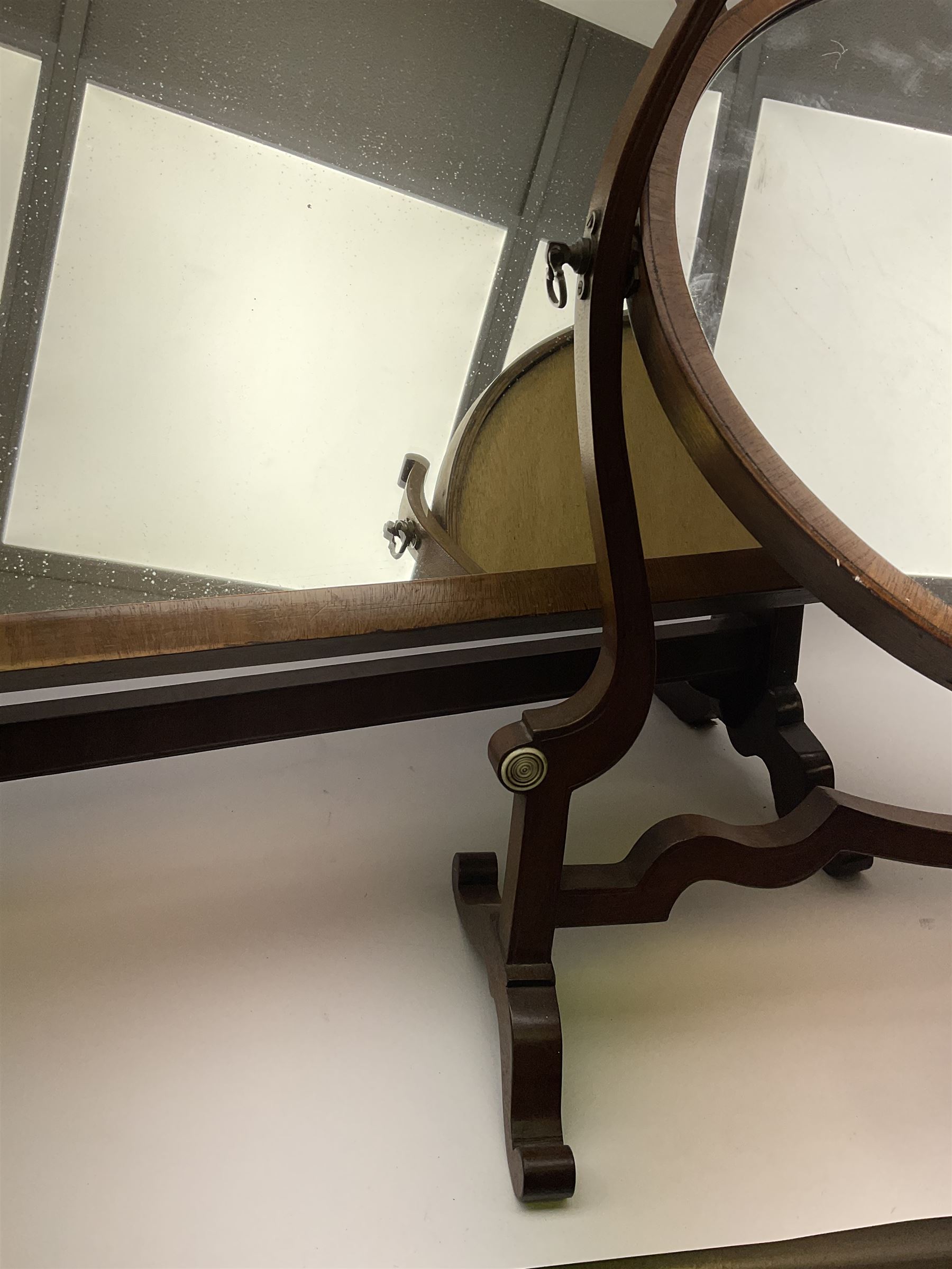 An Edwardian mahogany dressing table mirror, the oval mirror plate in swing frame, upon flared legs linked by stretcher, the frame detailed with turned roundels, H49cm, together with a Victorian mahogany example, H50cm. 