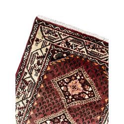 Persian Baluch red ground runner, seven lozenge medallions each decorated with stylised floral motifs, ivory border decorated with trailing pattern and Boteh motifs, within geometric guard stripes 