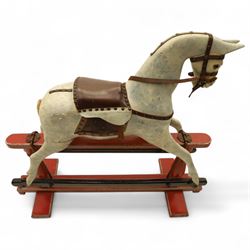 20th century carved and painted rocking horse, with original dappled paint finish, studded leather saddle and reins, on later red and black swing frame