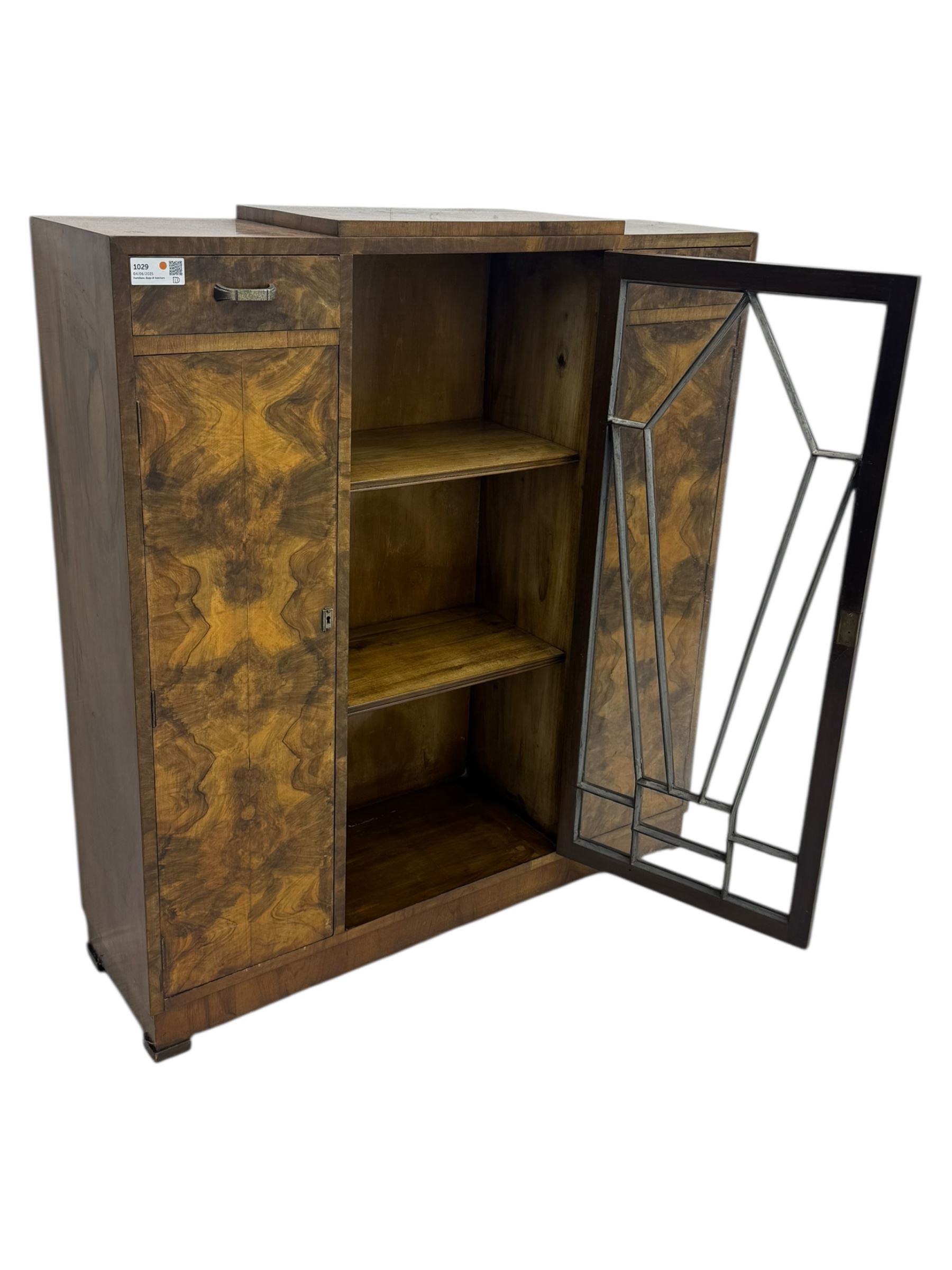 Art Deco burr walnut drinks cabinet, geometric central glazed astragal door enclosing two fixed shelves, flanked by symmetrical bookmatched veneered cupboards with drawers above 