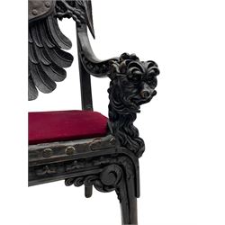 Grand mid-to-late 19th century heavily carved beech framed throne chair, the crown pediment carved with flower heads and cross finial, scroll and acanthus carved upright supports with twin perching griffin back enclosing etched leather work heraldic shield with castle and lion motifs over splayed feathers, flower head carved down sweeping arms with grotesque carved terminals, the seat rails carved with further flower heads on moulded supports with oversized ball and claw carved feet

Provenance: A very similar chair was used in the filming of Stanley Kubrick's 'Eyes Wide Shut' (1999)
