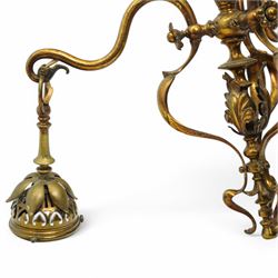 Early 20th century brass three-light chandelier, with Art Nouveau style curved and foliate ornamentation, the hanging branches formed as budding flowers with petal adornments, the bulb holders having pierced decoration to bowls, H43cm; together with two wall sconces