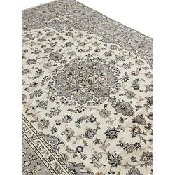 Persian Kashan ivory ground carpet, floral central medallion surrounded by trailing leafy branches and palmettes, floral pattern spandrels and matching border, within guard stripes