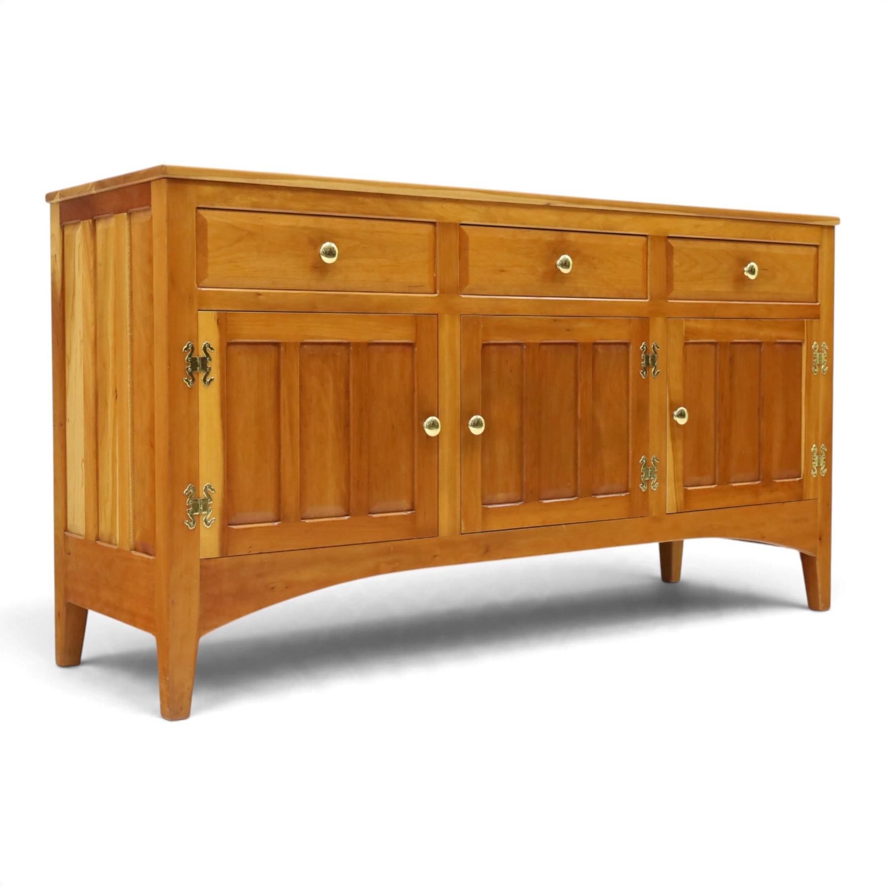 Traditional cherrywood sideboard, rectangular top above three fielded panelled drawers, three cupboard doors with triple panelled doors, brass knobs and hinges, tapered supports