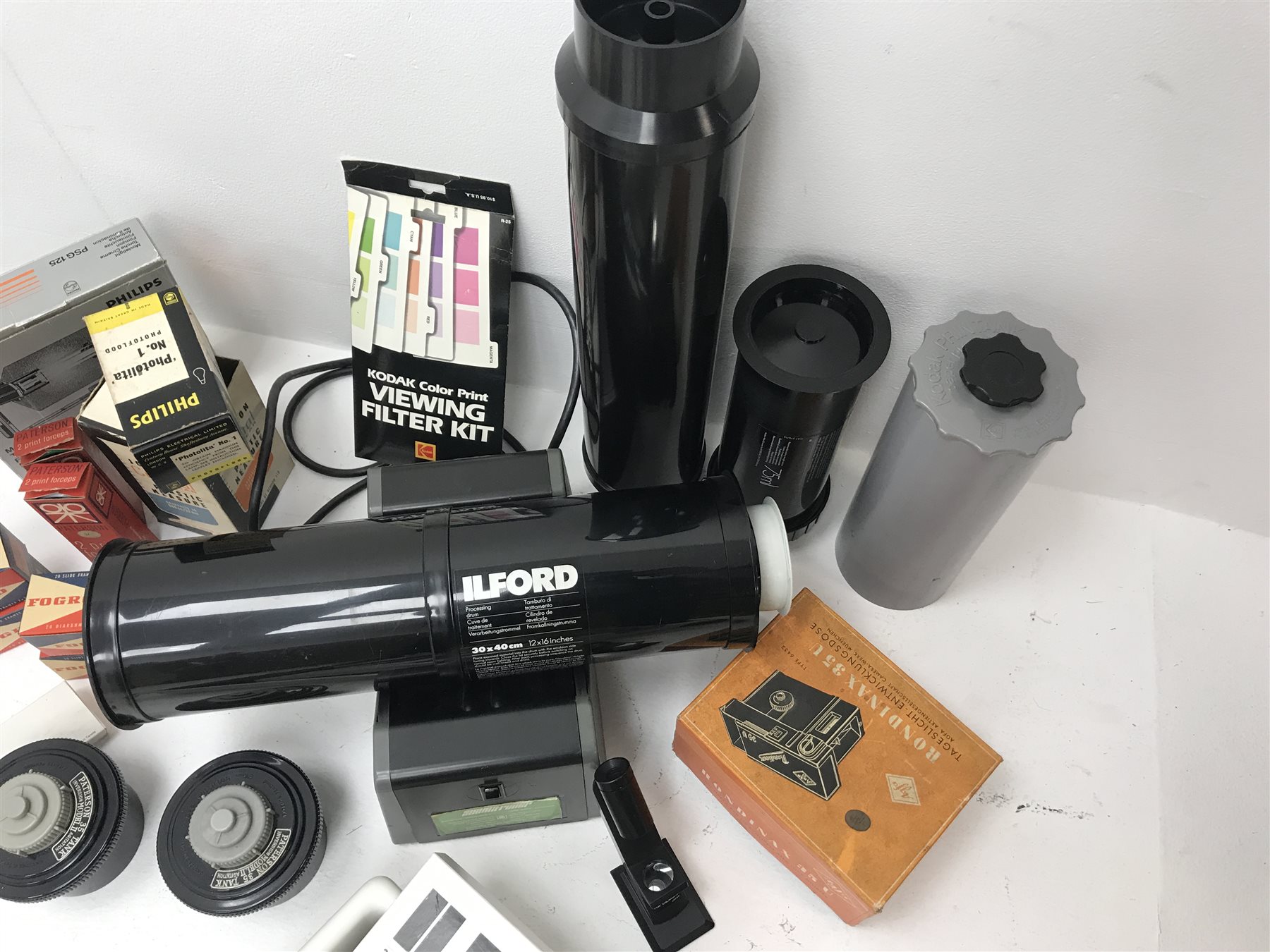 Large quantity of photo developing, dark room and photography equipment - quantity of Fogro 2'' x 2'' slide frames, PHILIPS movielight PSG125, Paterson 2 print forceps, atlas photo flash M3 clear, two Paterson 35mm developing tanks, Ilford photography paper 12'' x 16''and 8'' x 10'', Fujifilm photography paper 8'' x 10'' and 12'' x 16'', Rondinax 35U developing tank boxed, Simma Roller, two Ilford processing drums 30x40cm and 20x25cm, two other processing drums, Paterson 35mm contact proof printer, S&K 60D-C colour analyser etc... in three boxes