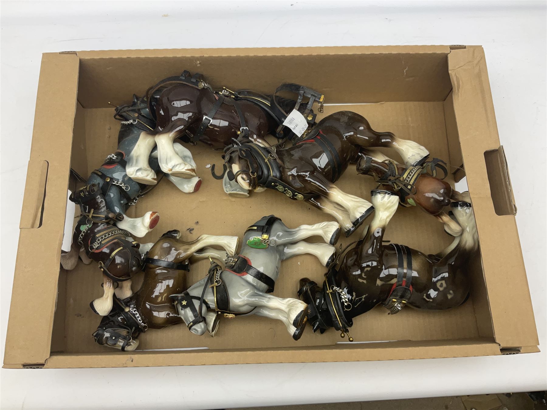 Approximately forty seven ceramic Shire horses to include Sylvac and Melba Ware examples of various sizes and colours, many with harnesses, and a quantity of carts and wagons 