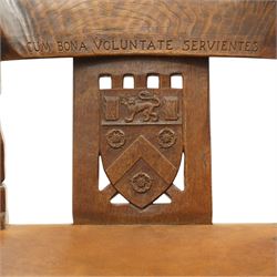 Mouseman - important oak monks chair, c1930s, the curved back inscribed with motto 'Cum Bona Voluntate Servientes' (serving with goodwill) over Trinity College Cambridge coat of arms, the shaped arms terminating with carved monks heads, each pierced side panel with Yorkshire Rose, tan leather seat on four octagonal legs joined by a cross stretcher, the back of the chair with initials ECH, with carved mouse signature, by Robert Thompson of Kilburn