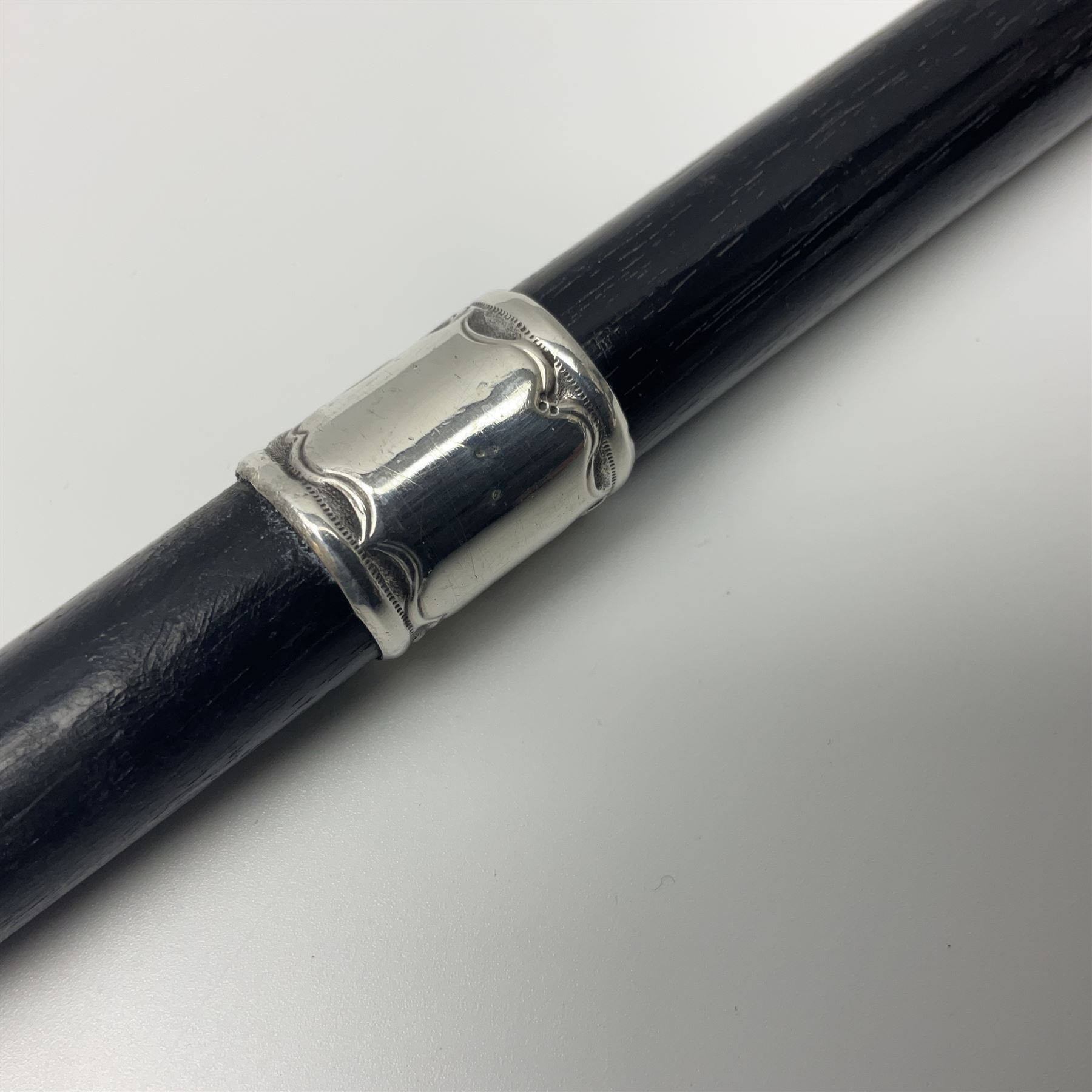 Two early 20th century conductor's ebonised batons each with three silver mounts; one hallmarked London 1915 with presentation plaque 'I.O.R. Presented to Mr. J.R. Maddock 4.1.17' L52cm; the other hallmarked Chester 1908 with vacant cartouche L51.5cm (2)