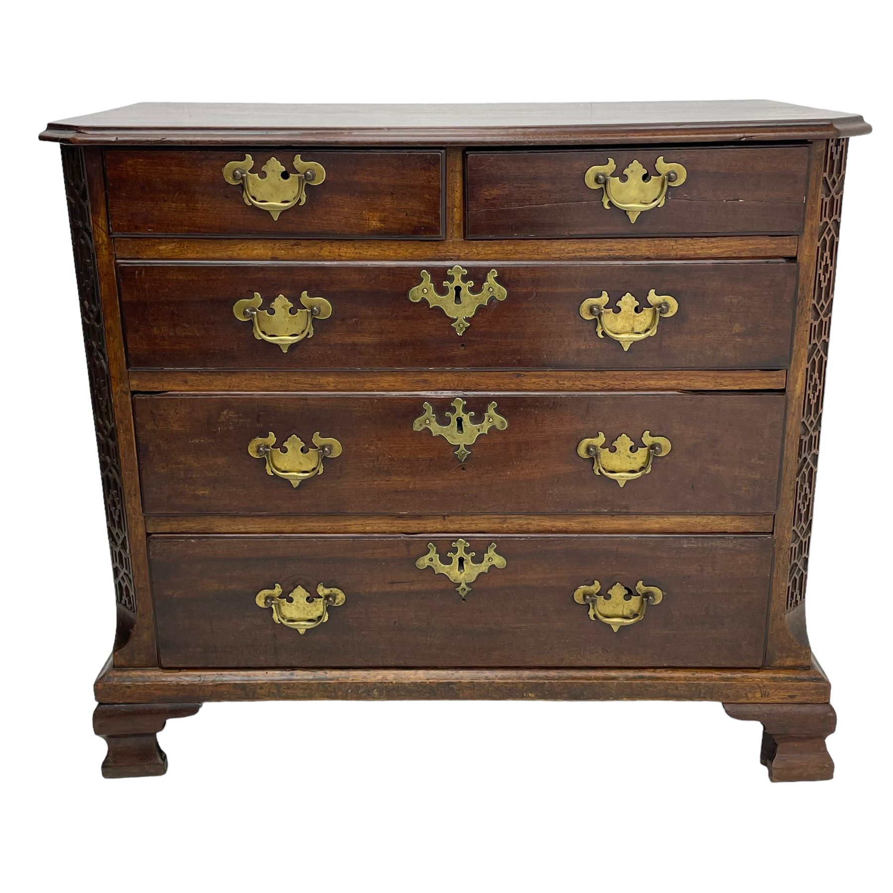 George III Chippendale design mahogany chest, moulded rectangular top with canted corners, wide canted uprights with blind fretwork decoration, two short and three long with moulded fronts, shaped brass handle plates, on ogee bracket feet 