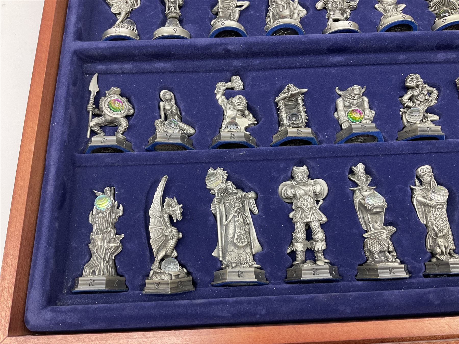 Danbury Mint 'The Fantasy of the Crystal' chess set consisting of mythical pewter chess pieces within a wooden case with chess board lid, together with 16 additional chess pieces in a wooden display case.