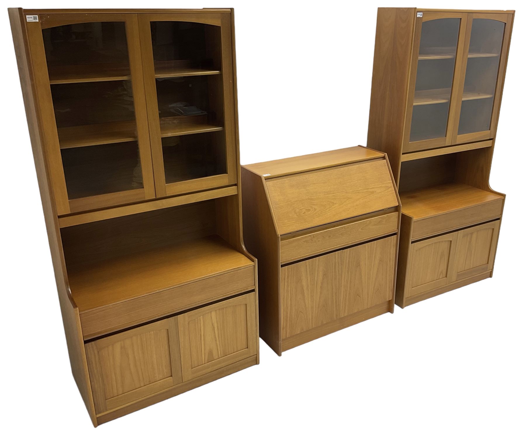 Sutcliffe of Todmorden - pair of teak wall units, fitted with two glazed doors over drawer and double cupboard (W86cm, D45cm, H198cm); and a matching fall front bureau (W84cm, D41cm, H100cm)