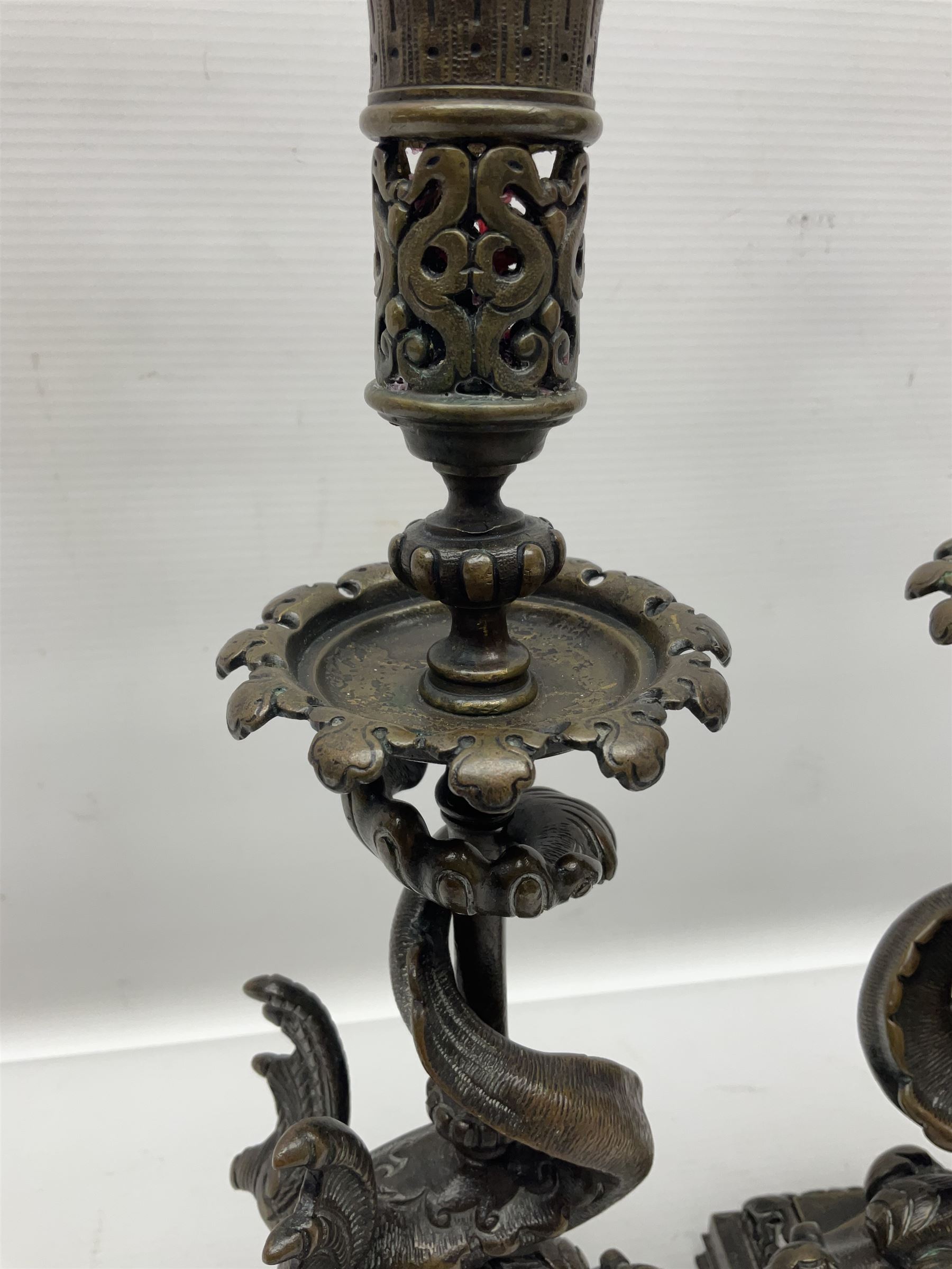 Pair of late 19th/ early 20th century brass candlesticks in the form of dolphins upon a stepped base with Fleur-de-lis design, H32cm 
