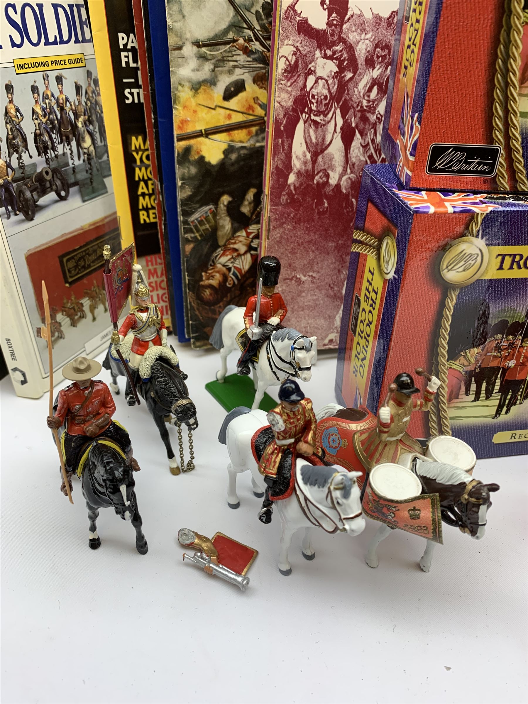 Britains - four Trooping the Colour sets 40109, 40110, 40112 & 40113; The Duke of Wellington with 95th Rifleman No.41160; and 8819 Lancer figure from the 16th Queens Lancers; all mint and boxed; together with a quantity of unboxed figures etc; and collection of books and magazines on model soldiers