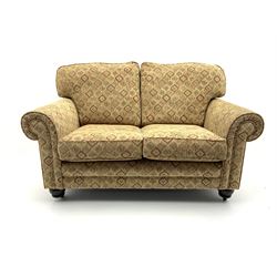 Alstons two seat sofa upholstered in beige patterned fabric, raised on turned supports and castors 
