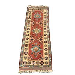 Turkish style runner rug, triple medallion surrounded by red field, inner floral boarder and patterned outer 
