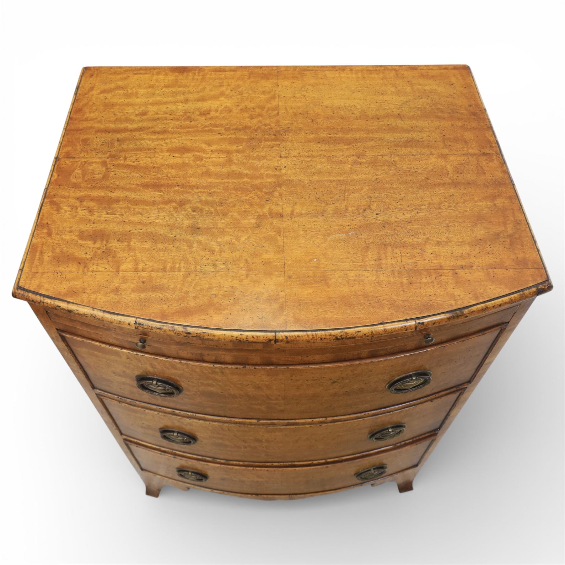 Georgian design bow front chest in figured walnut veneers, with moulded top over a pull-out brushing slide and three long drawers fitted with oval brass drop handles, raised upon swept bracket feet