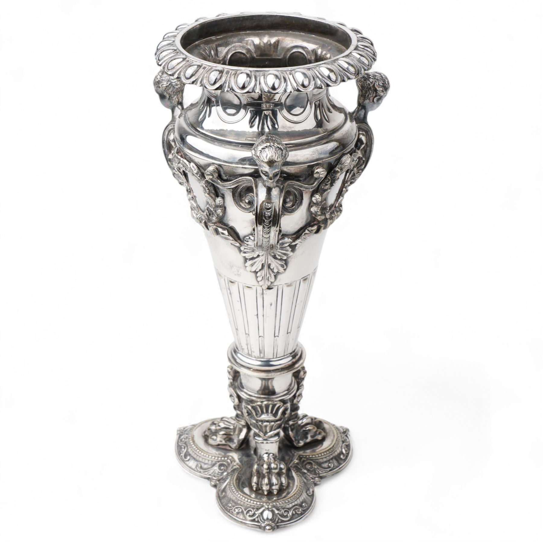 19th century silver plated vase of tapering form with lappet border and three caryatid handles surrounded with laurel wreath cartouches raised on triple paw feet on lobed base H28cm