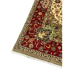 Persian Tabriz ivory ground carpet, the field with all over interlaced foliate decoration and central medallion, floral design border set with a series of stylised flower cartouche medallions