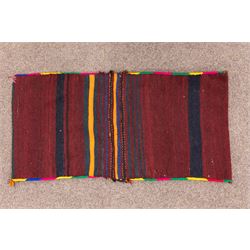 South West Persian Qashgai saddlebag, (Khorjin) saddlebag, comprising two pile-woven panels joined by a flatweave underside, each decorated with madder-red field filled stylized geometric motifs and hooked devices, enclosed by contrasting ivory borders populated with tribal figures and abstract forms