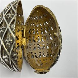Modern silver limited edition Easter egg, no. 70/500, the openwork lattice body decorated with gilded panels of flower heads, opening to reveal a gilt interior, upon silver stand with three scrolling pad feet, each hallmarked St James House Company, London 1979, height including stand 8cm