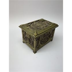 An Arts and Crafts brass and leather casket, decorated with scrolling tendrils and stylised buds or fruits, H8cm L12.5cm D9cm