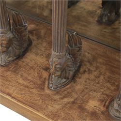20th century carved hardwood console table in Renaissance taste, moulded marble slab top over a frieze decorated with festoons and roundels, the angles carved with grotesque mask brackets, supported by six fluted columns with carved mask and paw feet terminals, on a stepped plinth base with mirrored back
